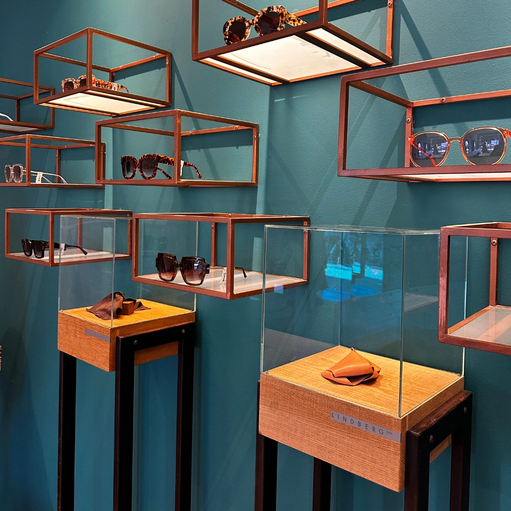 תצוגת משקפי שמש מעוצבים בחנות משקפיים, כולל מסגרות יוקרתיות של מותגים שונים.